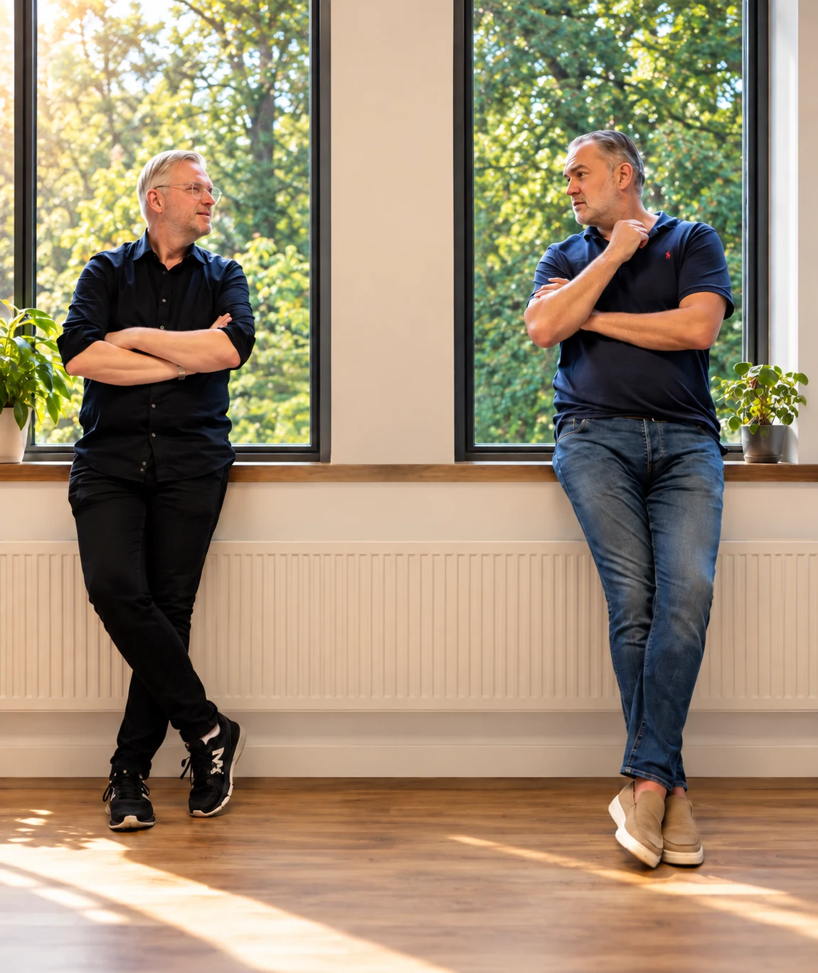 Josef Stevens en Bas Resink in gesprek bij het raam van de trainingslocatie in Hilversum